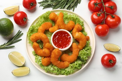 Delicious breaded fried shrimps served with sauce on white marble table, top view