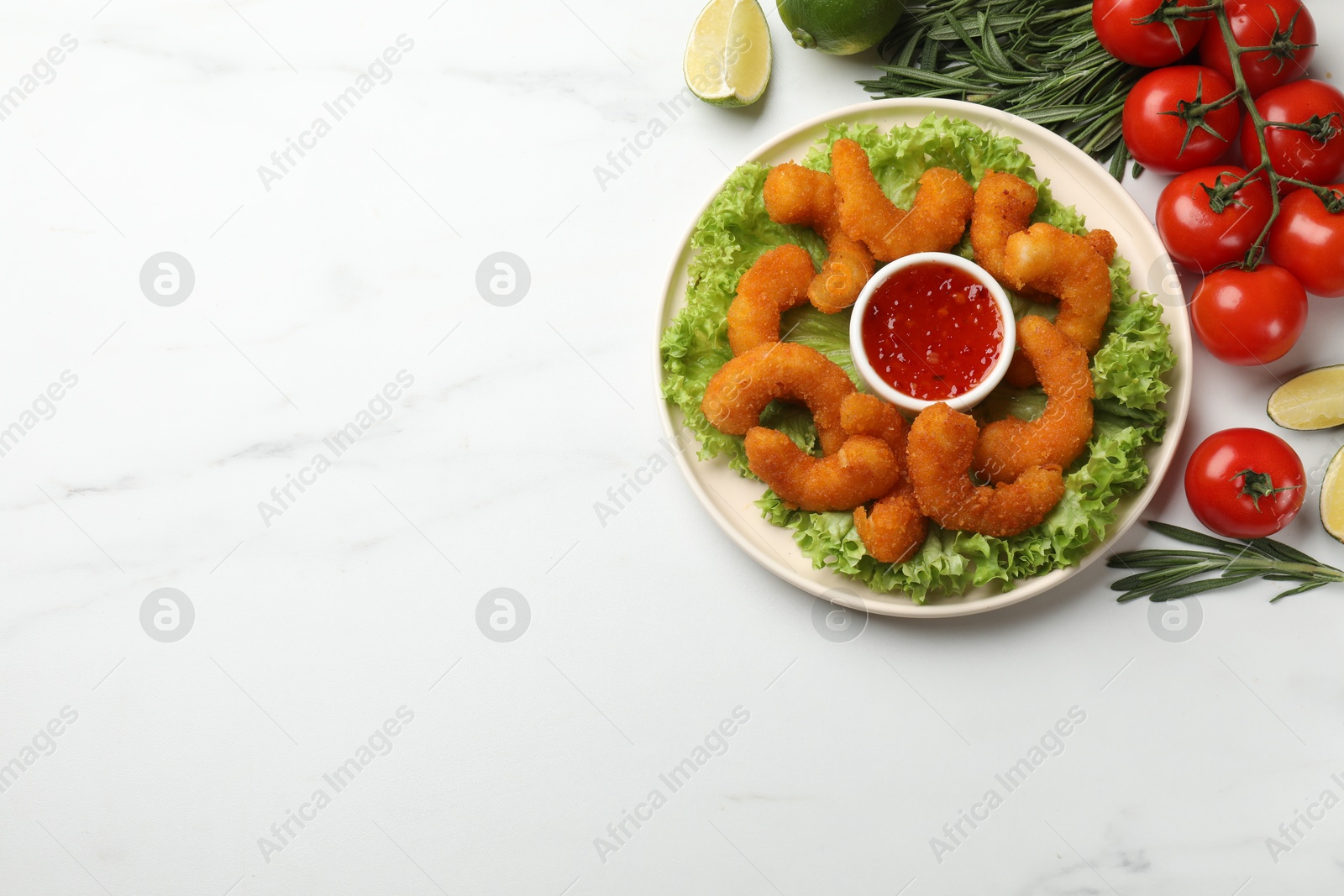 Photo of Delicious breaded fried shrimps served with sauce on white marble table, top view. Space for text