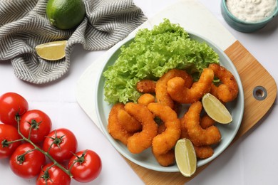 Delicious breaded fried shrimps served on white table, top view