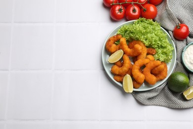 Photo of Delicious breaded fried shrimps served on white tiled table, top view. Space for text