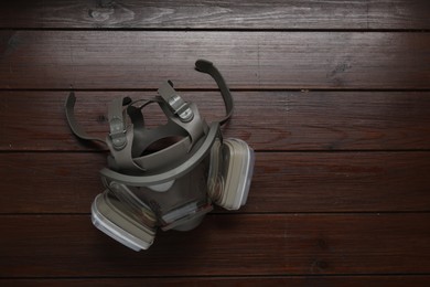 One respirator mask on wooden table, top view. Space for text