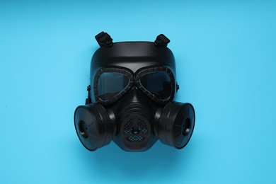 Photo of One gas mask on light blue background, top view