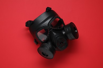 One gas mask on red background, top view