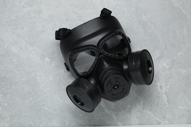 One gas mask on grey table, top view. Safety equipment