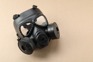 Photo of One respirator mask on beige background, top view and space for text. Safety equipment