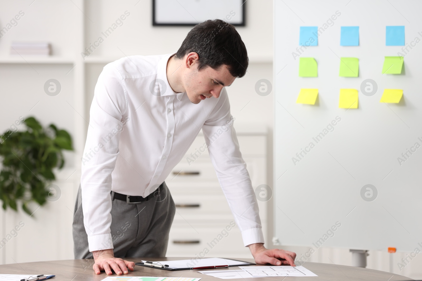Photo of Embarrassed man near table with documents in office