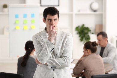 Man feeling embarrassed during business meeting in office