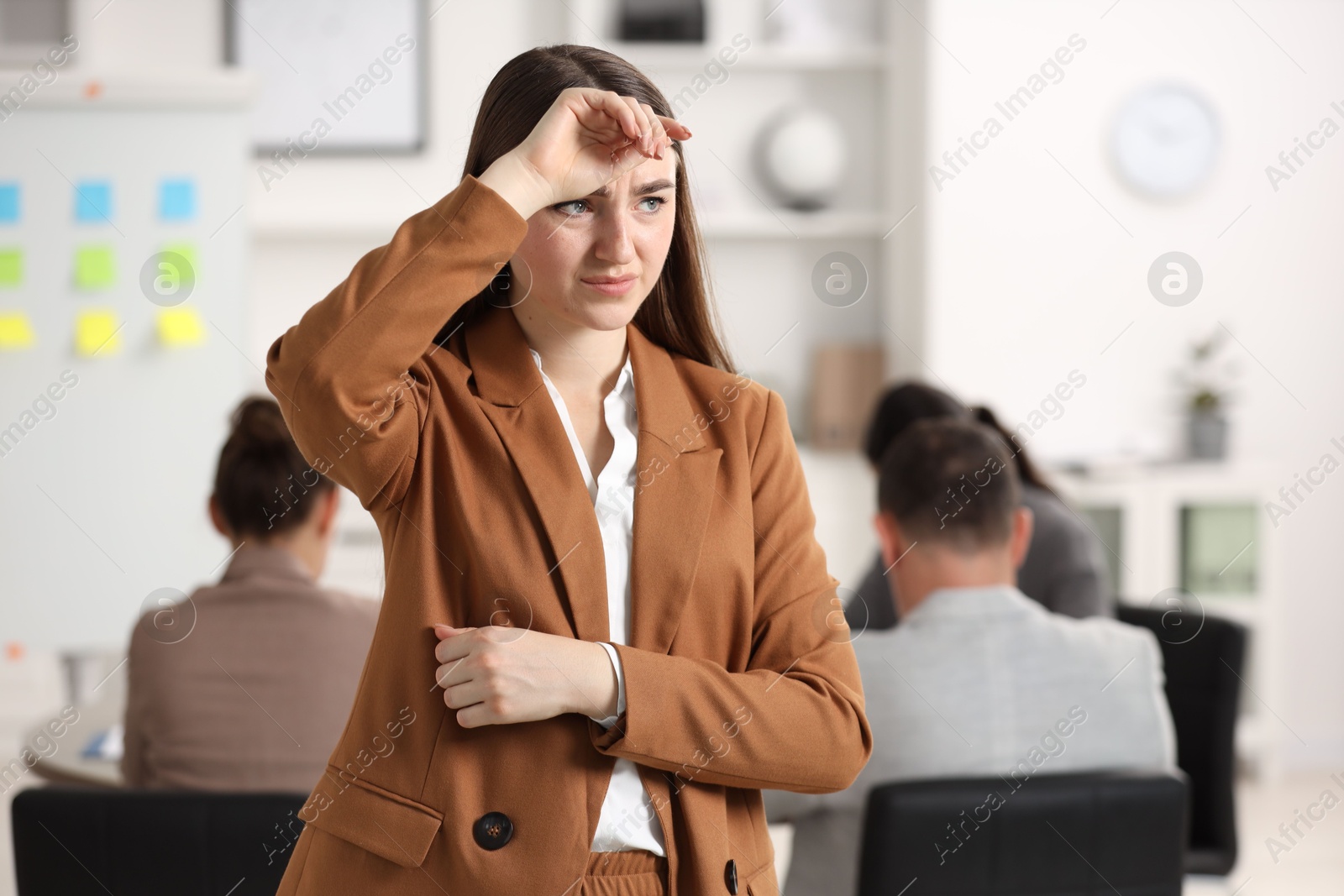 Photo of Woman feeling embarrassed during business meeting in office