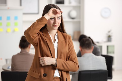 Photo of Woman feeling embarrassed during business meeting in office