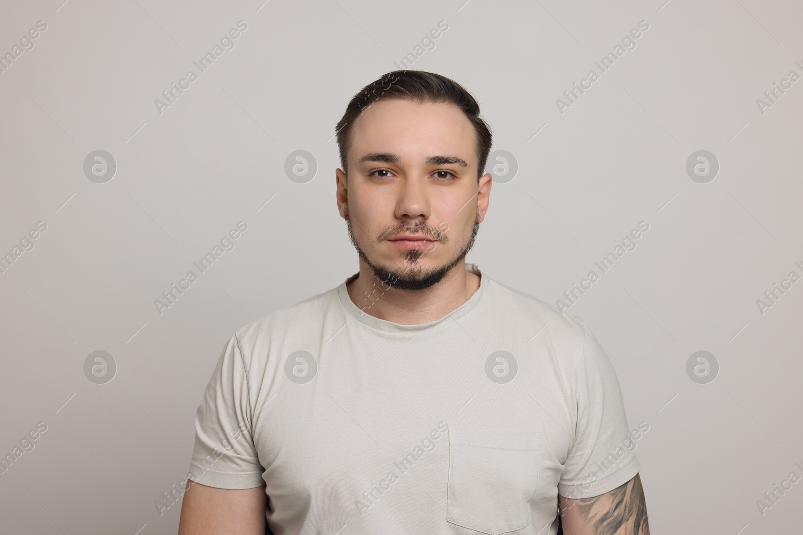 Photo of Baldness concept. Sad man with receding hairline on light grey background