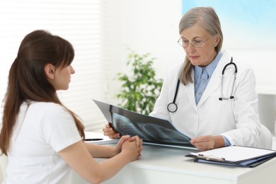 Photo of Lung disease. Doctor with chest x-ray consulting patient in clinic