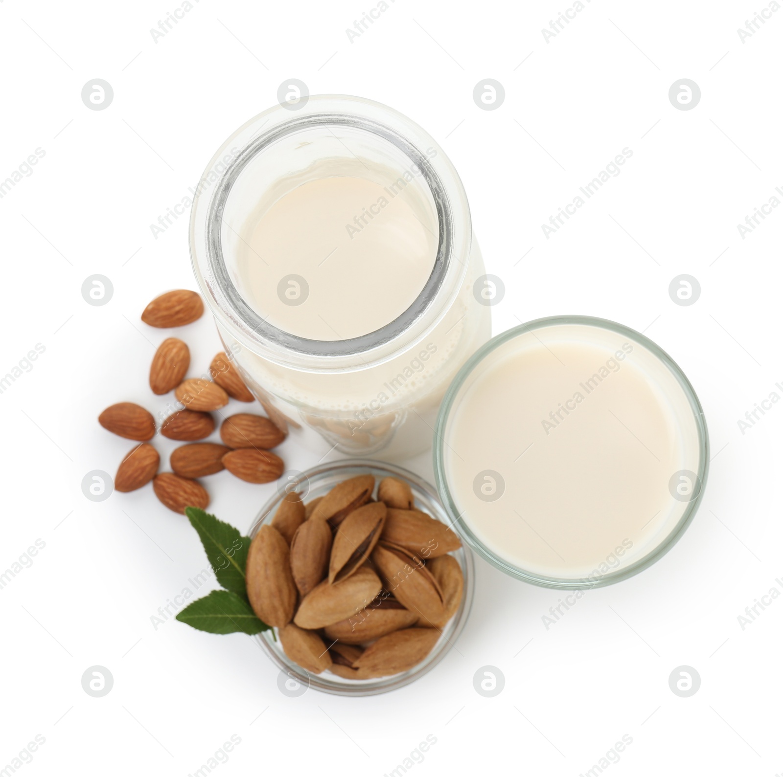 Photo of Glass of almond milk, jug and almonds isolated on white, top view