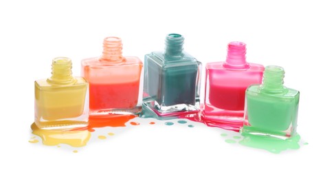 Photo of Many bottles and drops of colorful nail polishes isolated on white