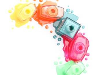 Photo of Many bottles and drops of colorful nail polishes isolated on white, top view