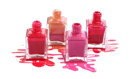 Many bottles and spilled nail polishes isolated on white