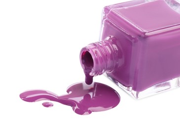 Photo of Bottle and spilled purple nail polish isolated on white