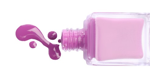 Photo of Bottle and spilled purple nail polish isolated on white, top view