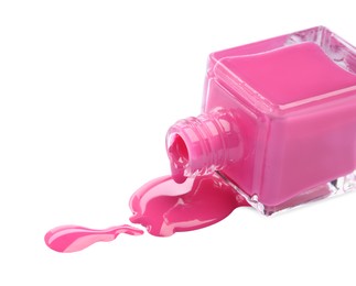 Bottle and spilled pink nail polish isolated on white