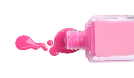 Bottle and spilled pink nail polish isolated on white, top view