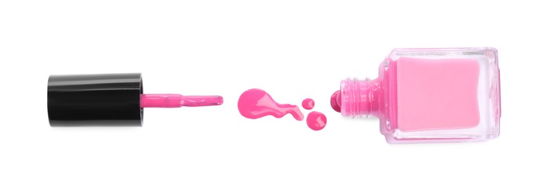 Bottle, brush and spilled pink nail polish isolated on white, top view