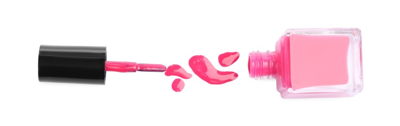 Bottle, brush and spilled pink nail polish isolated on white, top view