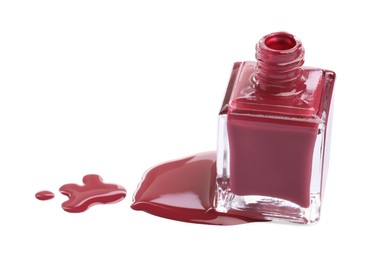 Photo of Bottle and spilled red nail polish isolated on white