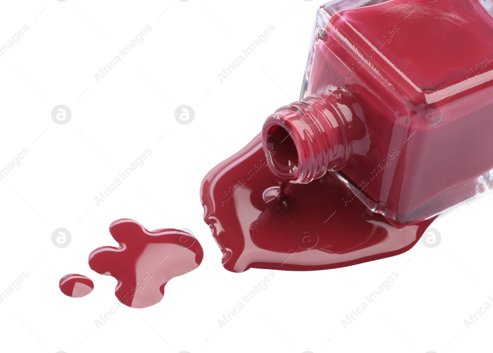 Photo of Bottle and spilled red nail polish isolated on white