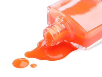 Photo of Bottle and spilled orange nail polish isolated on white