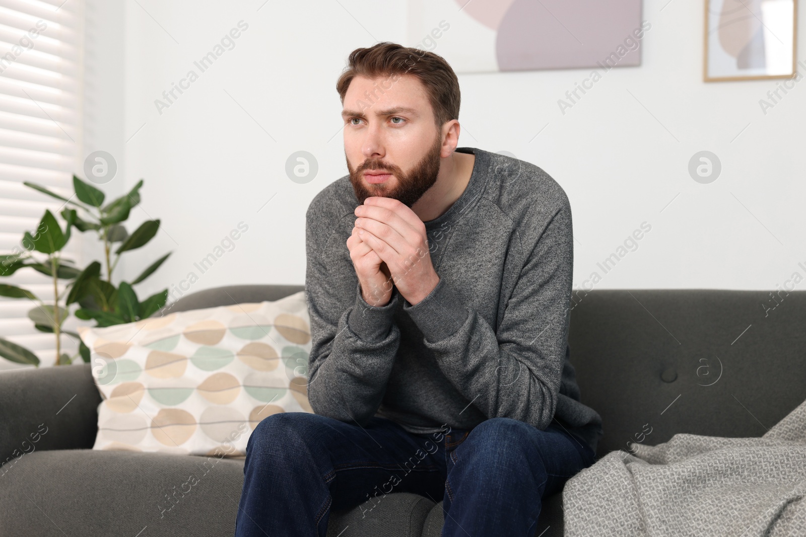 Photo of Loneliness concept. Sad man sitting on sofa at home