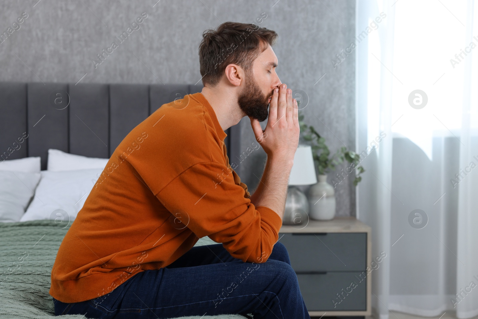 Photo of Loneliness concept. Sad man sitting on bed at home