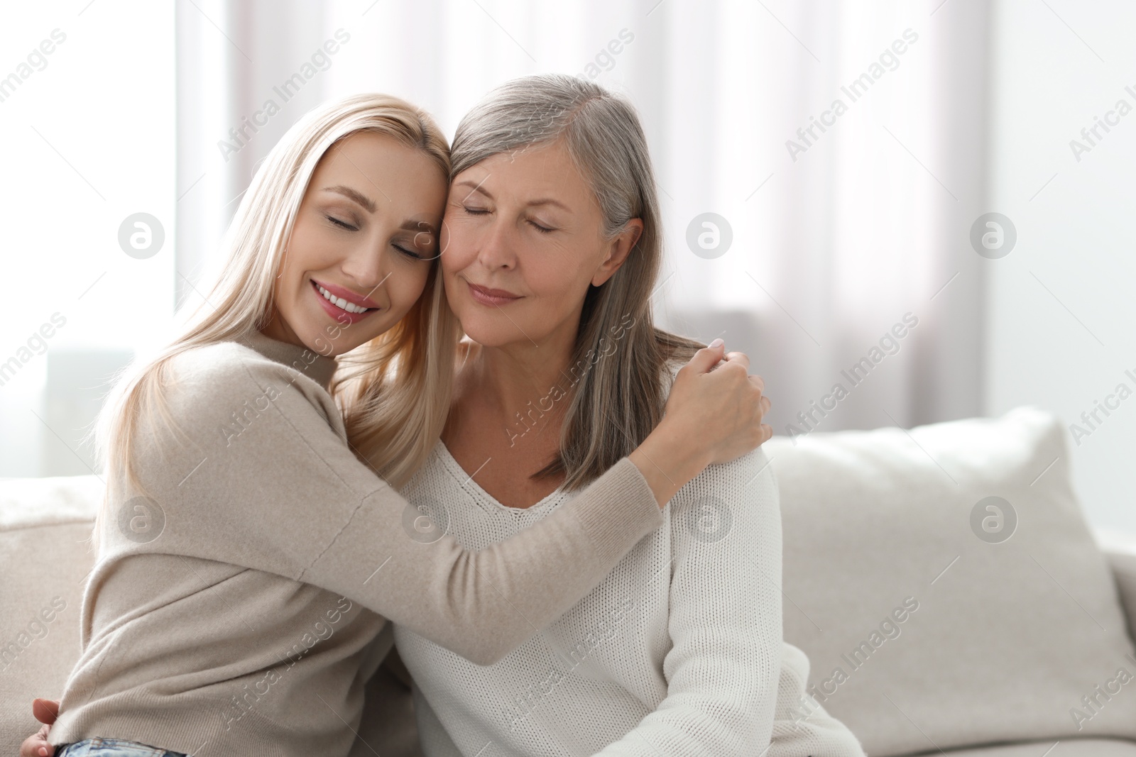 Photo of Family portrait of young woman and her mother at home