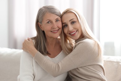 Family portrait of young woman and her mother at home