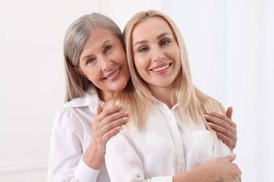 Photo of Family portrait of young woman and her mother on white background