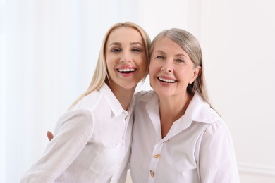 Family portrait of young woman and her mother on white background