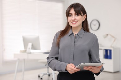 Portrait of smiling secretary with tablet in office. Space for text