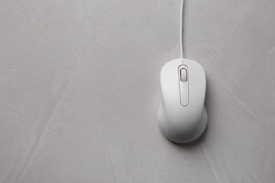 One wired mouse on grey textured table, top view. Space for text
