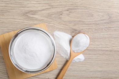 Photo of Baking soda in glass jar on wooden table, top view. Space for text