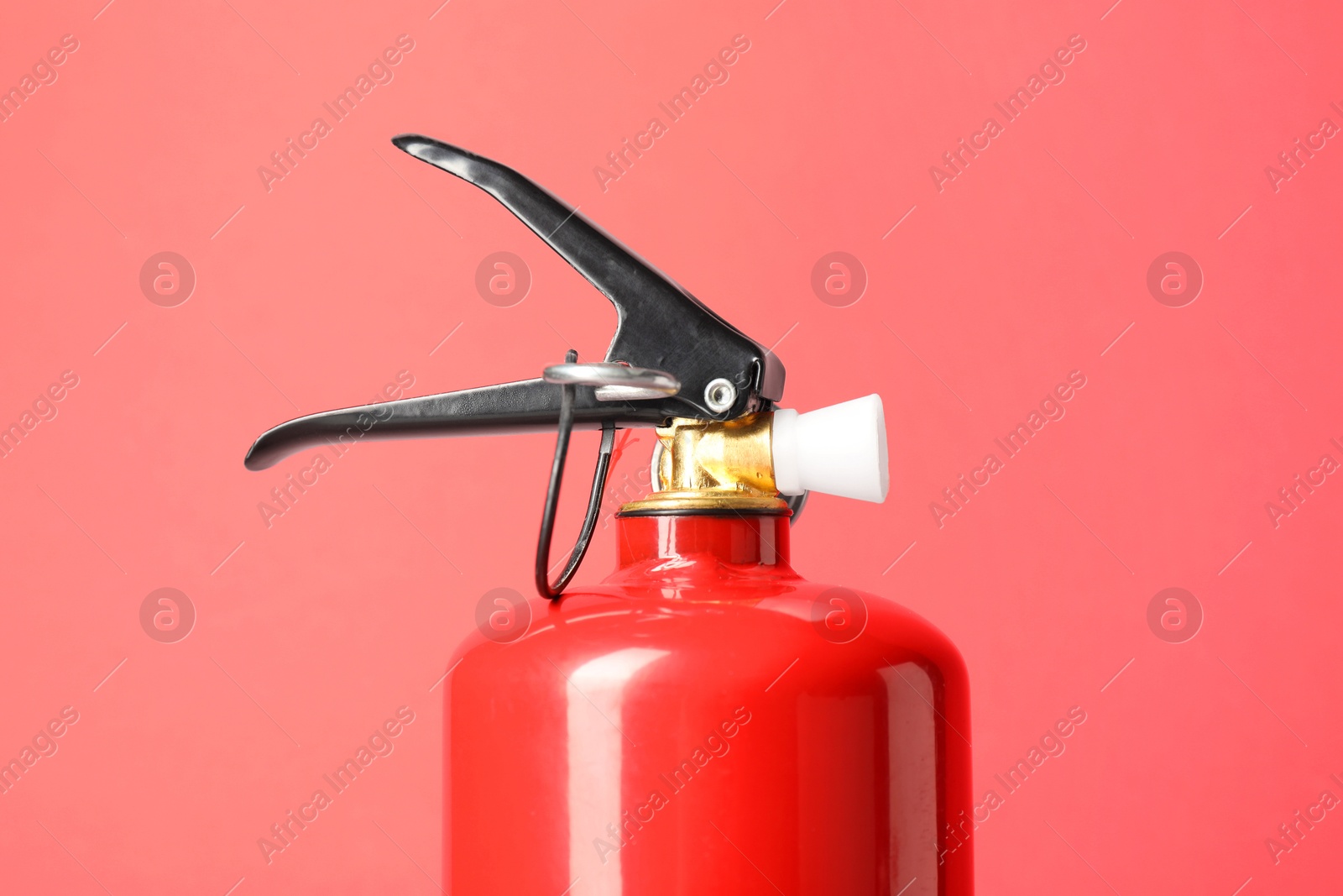 Photo of One fire extinguisher on red background, closeup