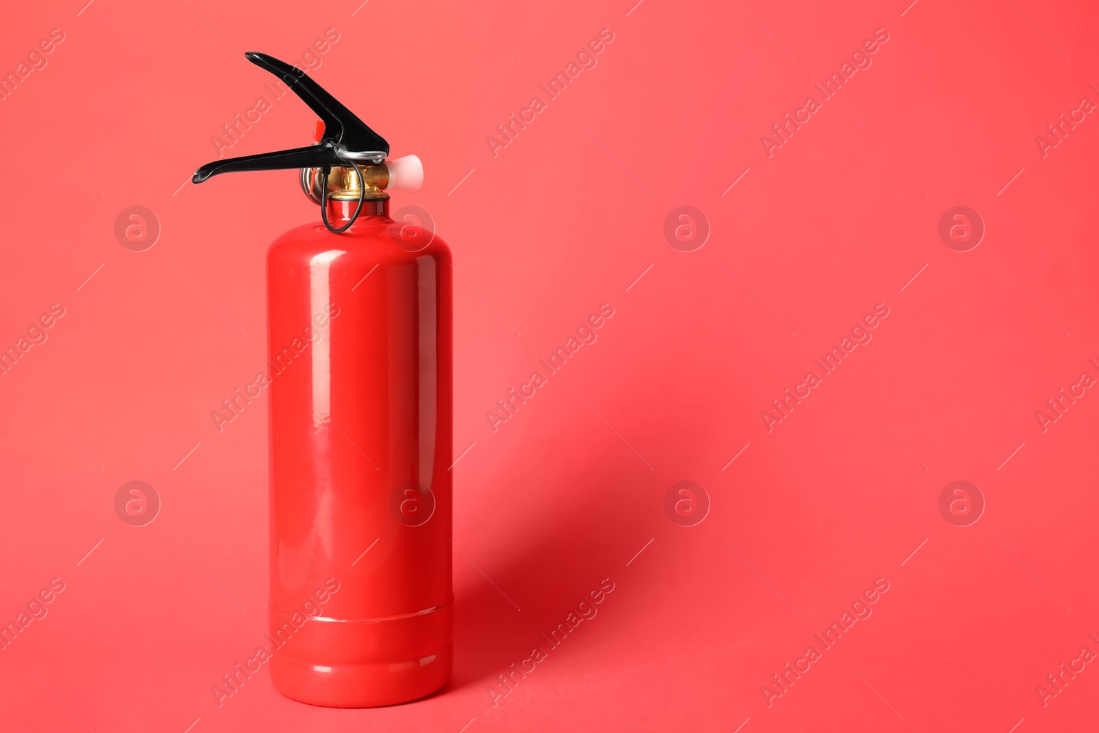 Photo of One fire extinguisher on red background, space for text