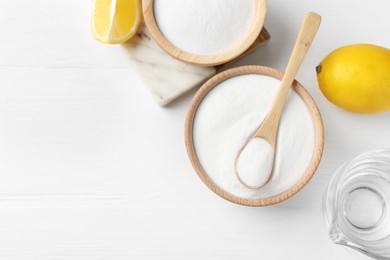 Photo of Baking soda, vinegar and lemons on white wooden table, flat lay. Space for text