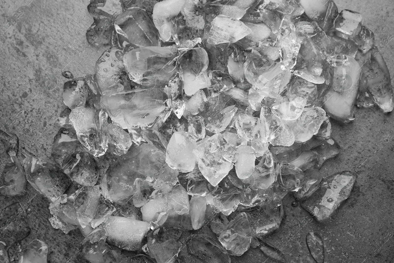 Photo of Pile of crushed ice on dark textured table, top view