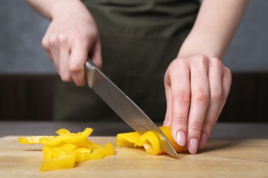 Photo of Healthy food. Woman cutting pepper at table, closeup