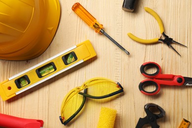 Photo of Flat lay composition with building level and other different construction tools on wooden background