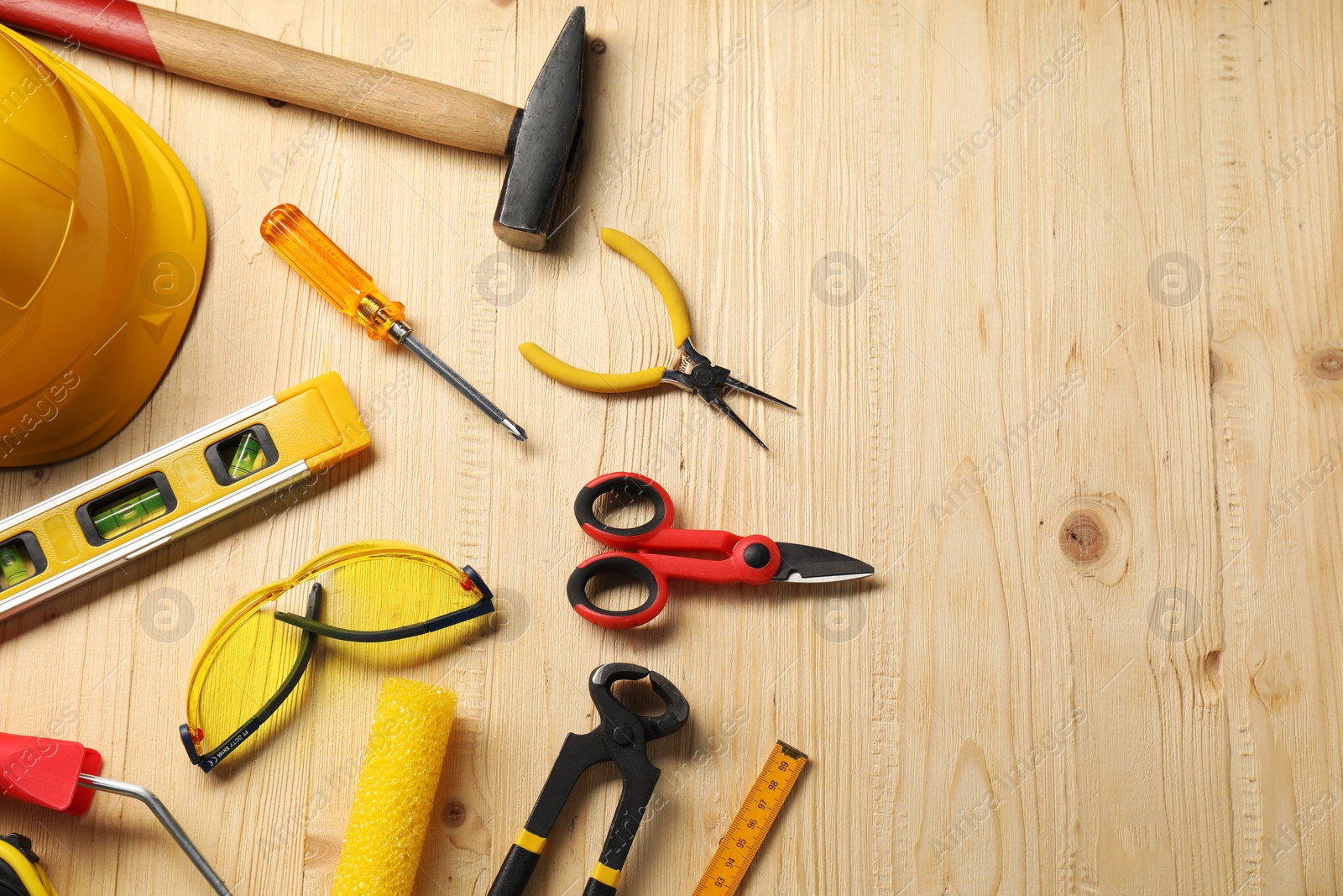 Photo of Flat lay composition with building level and other different construction tools on wooden background, space for text