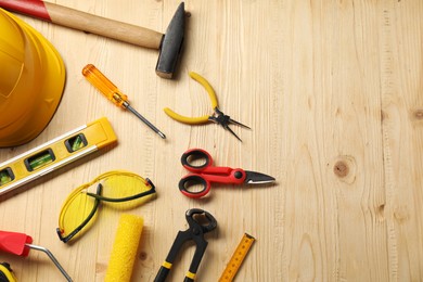 Photo of Flat lay composition with building level and other different construction tools on wooden background, space for text