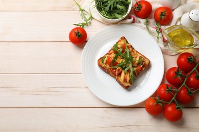 Tasty pizza toasts and ingredients on light wooden table, flat lay. Space for text
