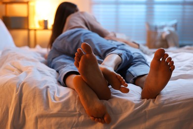 Couple enjoying each other on bed indoors at night, selective focus
