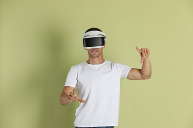 Photo of Man using virtual reality headset on light green background