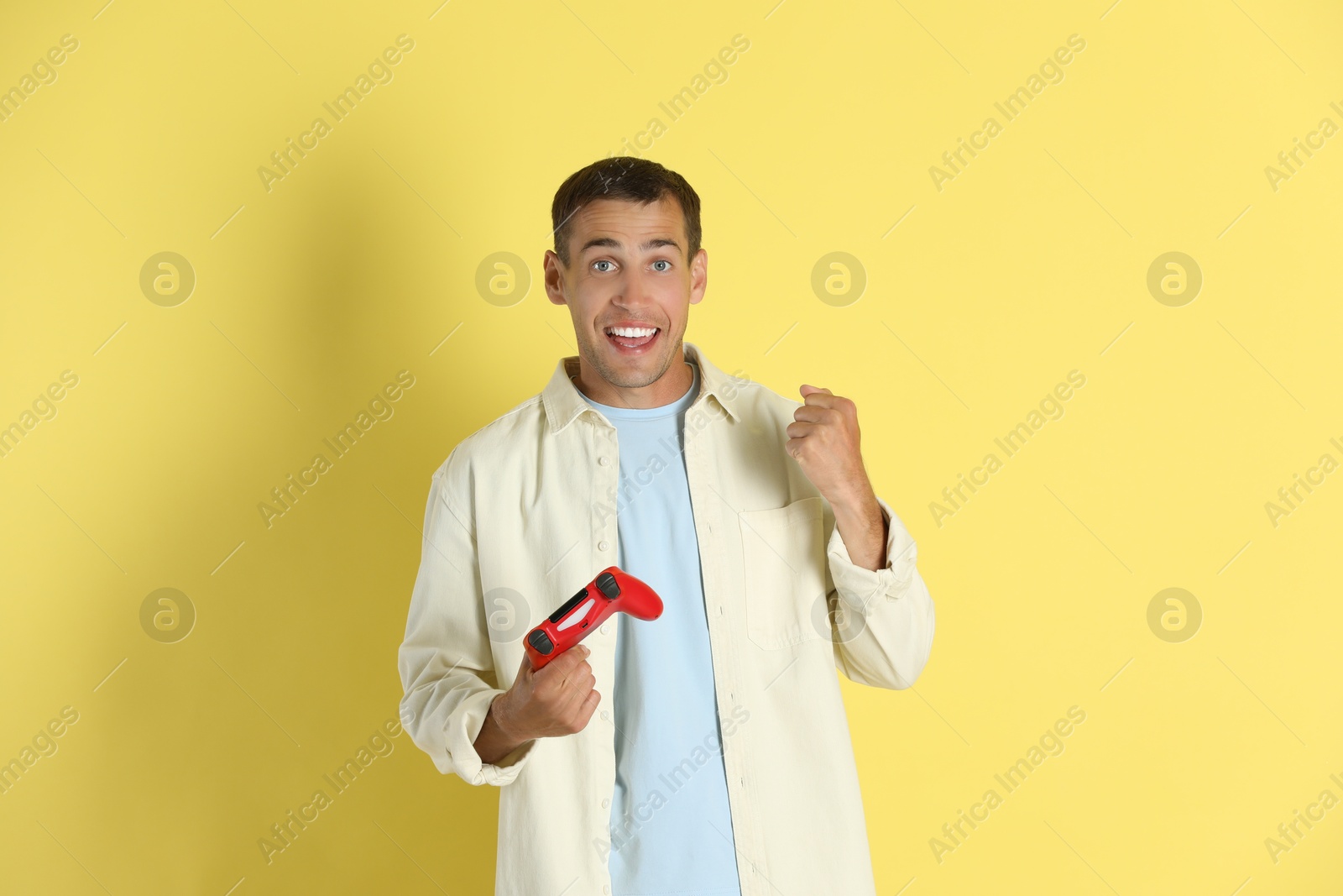 Photo of Happy man with controller on yellow background