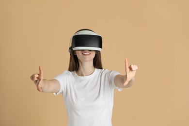 Photo of Smiling woman using virtual reality headset on beige background